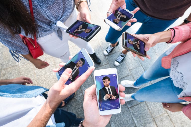 A group of people playing HQ Trivia on their phones.
