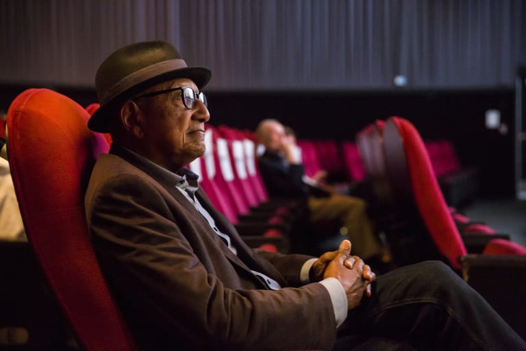 man in shit with hat and glasses i the cinema