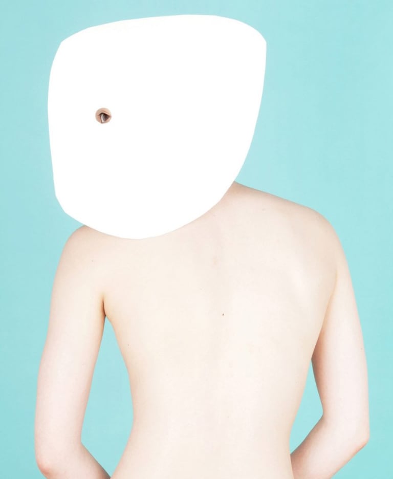 A person with there face whited out and a eye showing. A nude person standing backwards.