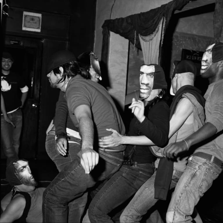 A group of people who are all wearing the same mask dancing.