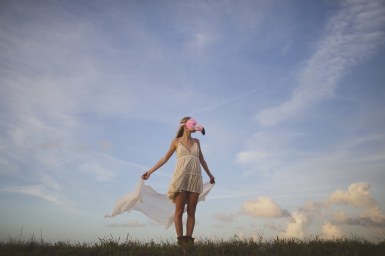 Girl in white dress and flamingo mask