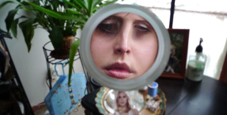 Woman's face in a magnifying make up mirror