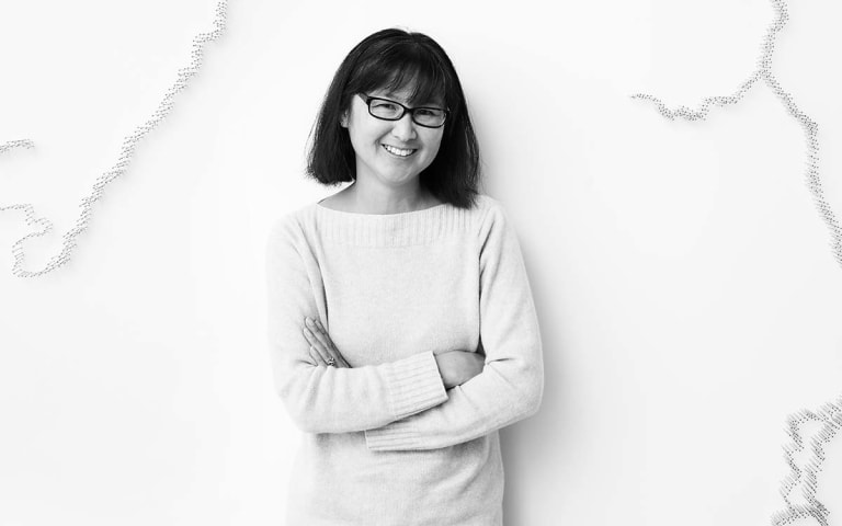 A black and white picture of an Asian woman wearing eyeglasses.