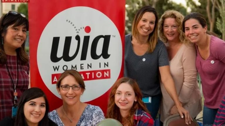 Women are posing in front of poster for WIA:Women in Animanation.