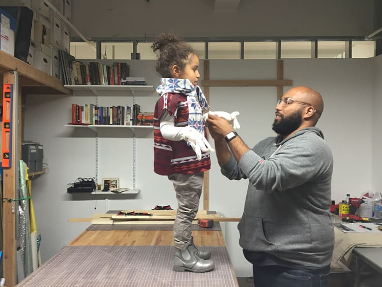 A father dressing his child standing on the table