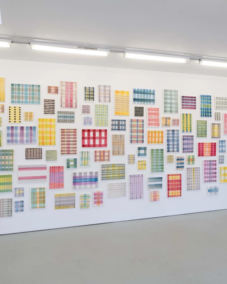 Untitled, 2021, secco fresco by Michelle Grabner. A series of small paintings of different kinds of plaid hung on a white wall of a gallery.