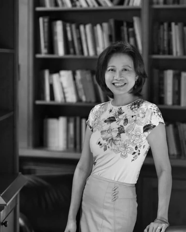 Scholar Anne Anlin Cheng standing in front of bookshelf, black and white photo