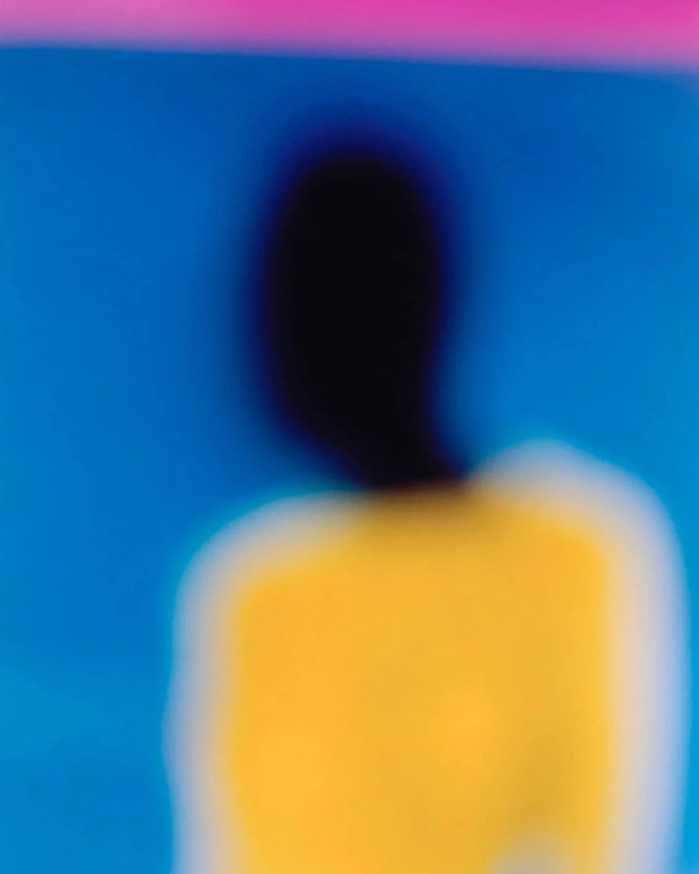 a yellow, blue and magenta portrait of a figure with a dark face.