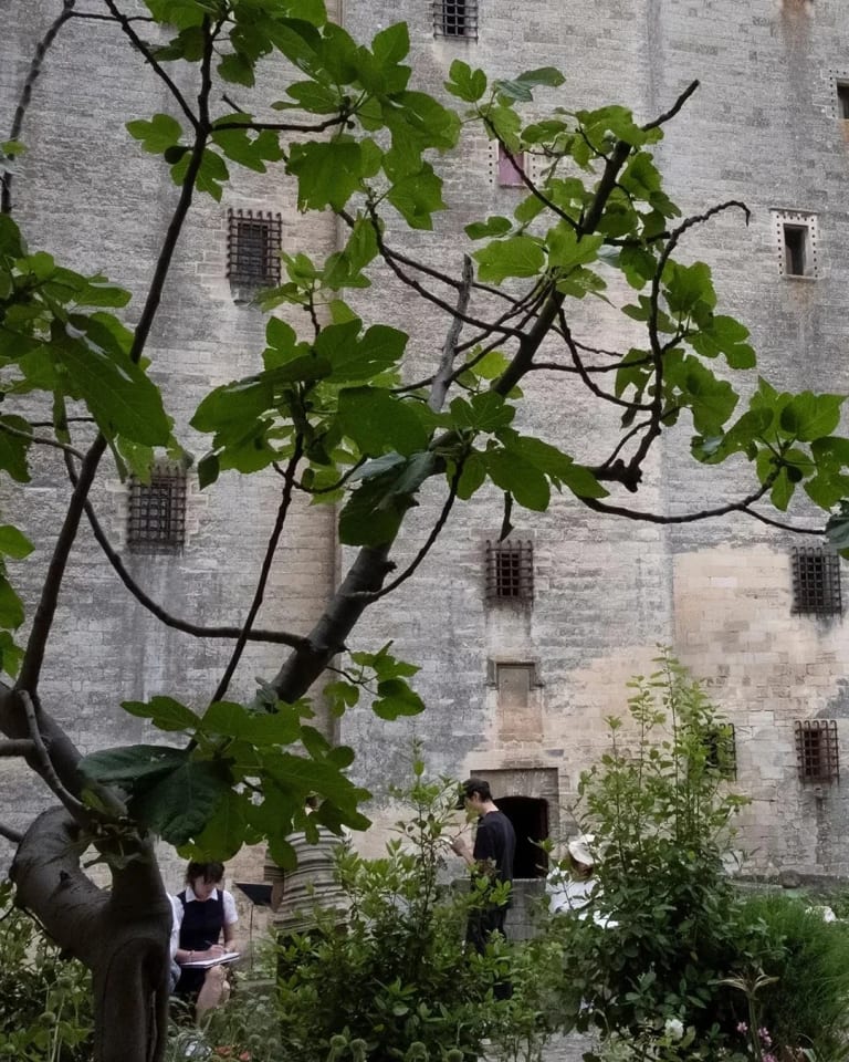 people sketch in garden outside castle