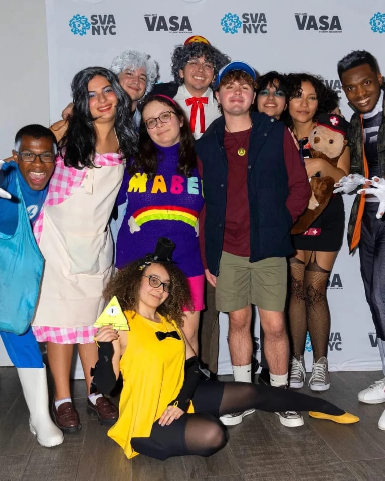 A group of students pose for the camera, all dressed in various Halloween costumes.