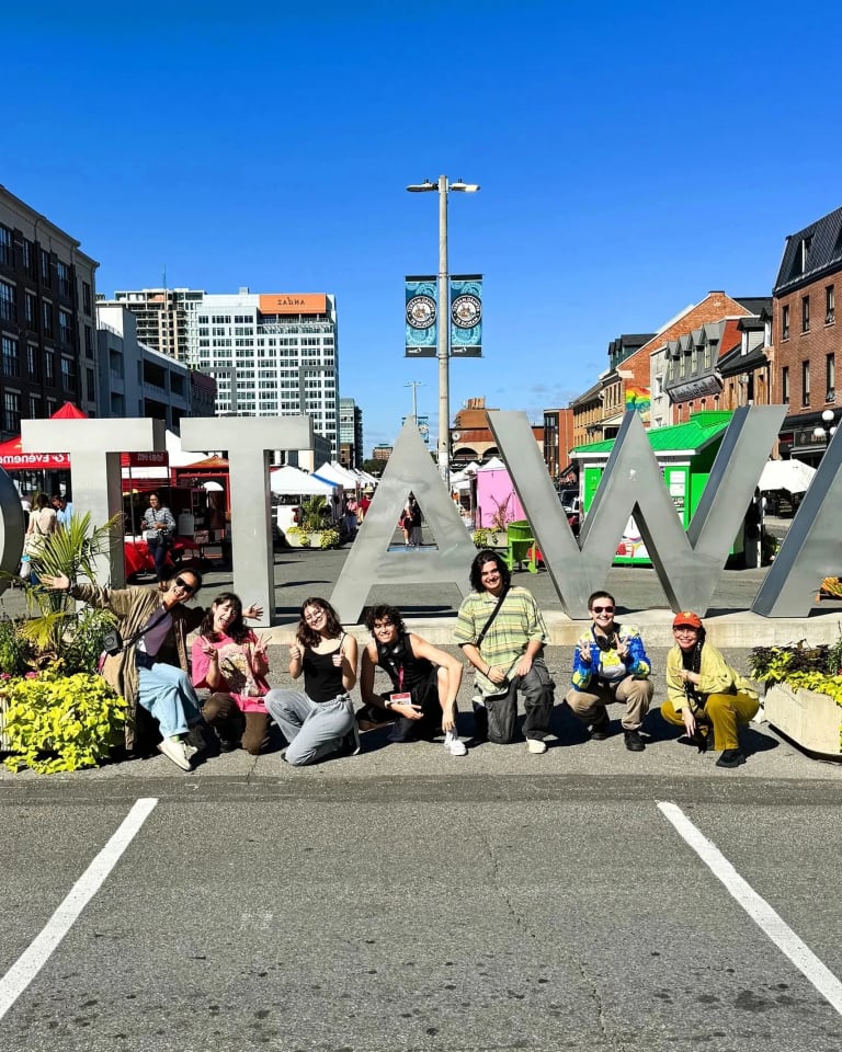 A group of students pose outside an Ottawa sign in Ottawa, Canada. 