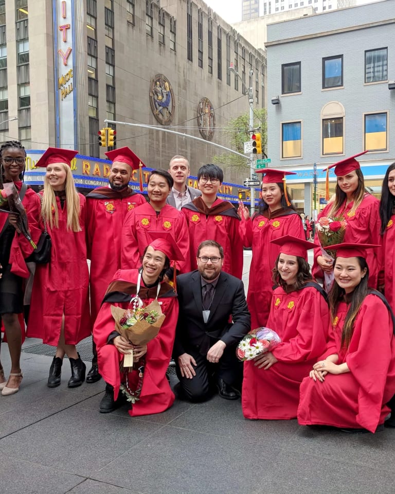 The graduating MPSDP class of 2019 stands on the street with the Radio City Music Hall in the background.