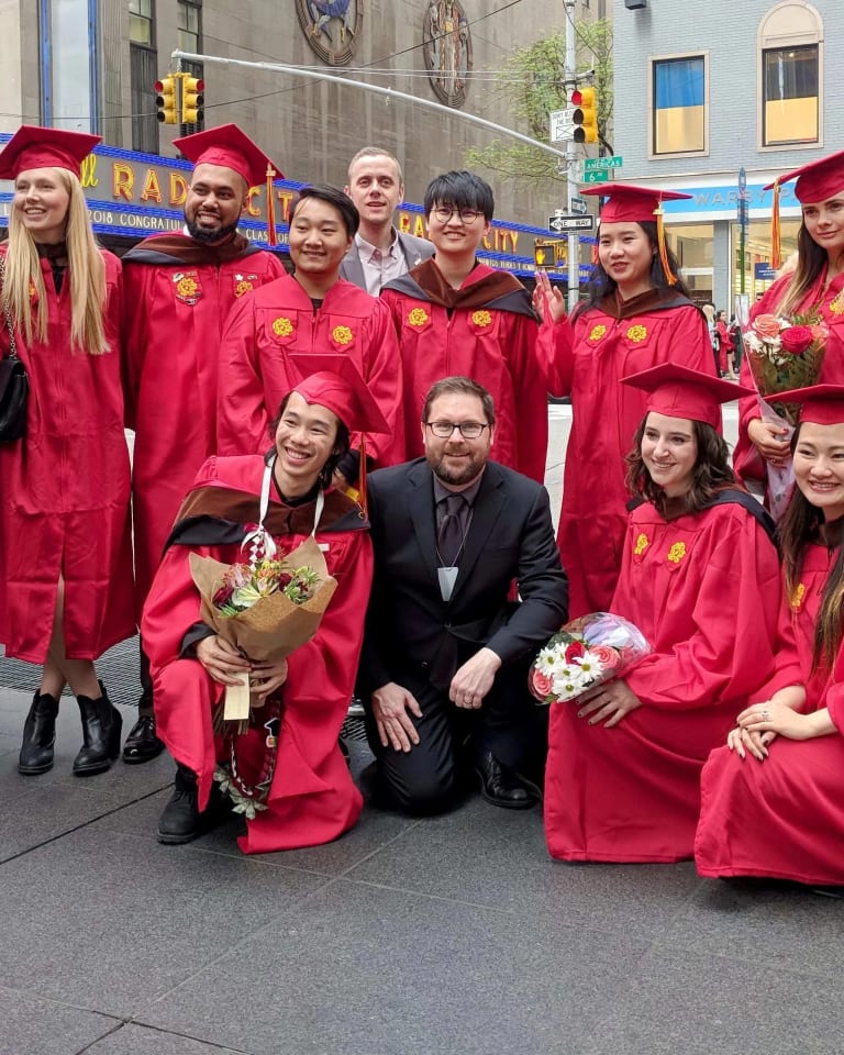 The graduating MPSDP class of 2019 stands on the street with the Radio City Music Hall in the background.