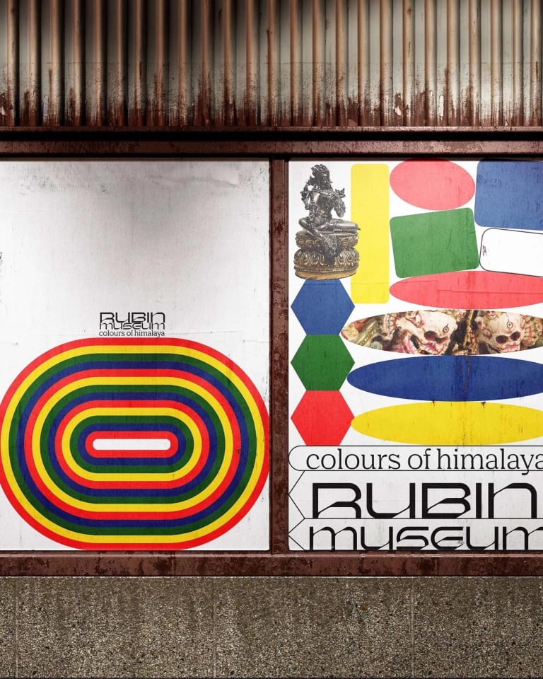 An urban display of various posters for the Rubin Museum, which includes an intricate sculpture image and multicolored geometric elements.