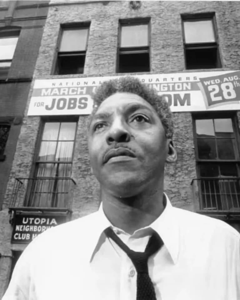 black-and-white photo of Bayard Rustin in front of the March on Washington office