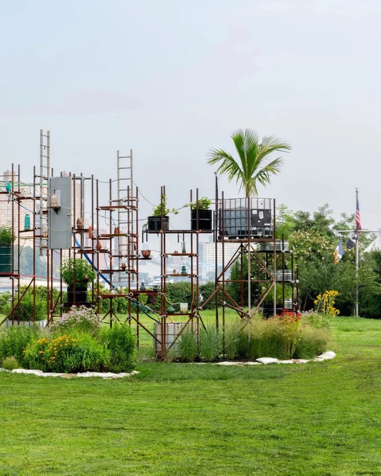 (Detail) Sculpture by the artist Mary Mattingly entitled Ebb of a Spring Tide at Socrates Sculpture Park, photo Alexa Hoyer, courtesy of the artist and Robert Mann Gallery. The sculpture is a scaffold-like structure holding plants connected by an irrigation system of tubes.