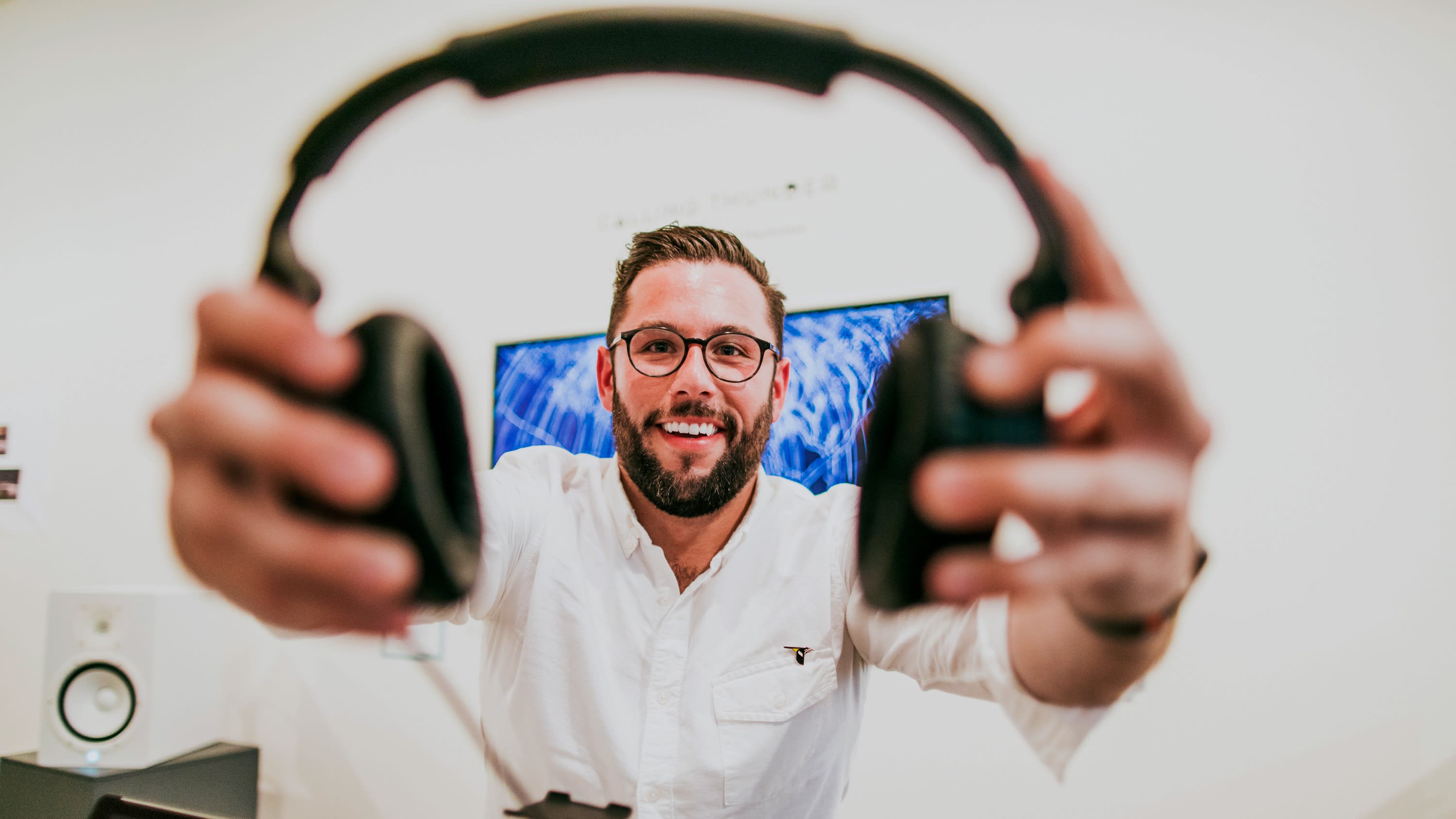 Student offering headphones to viewer