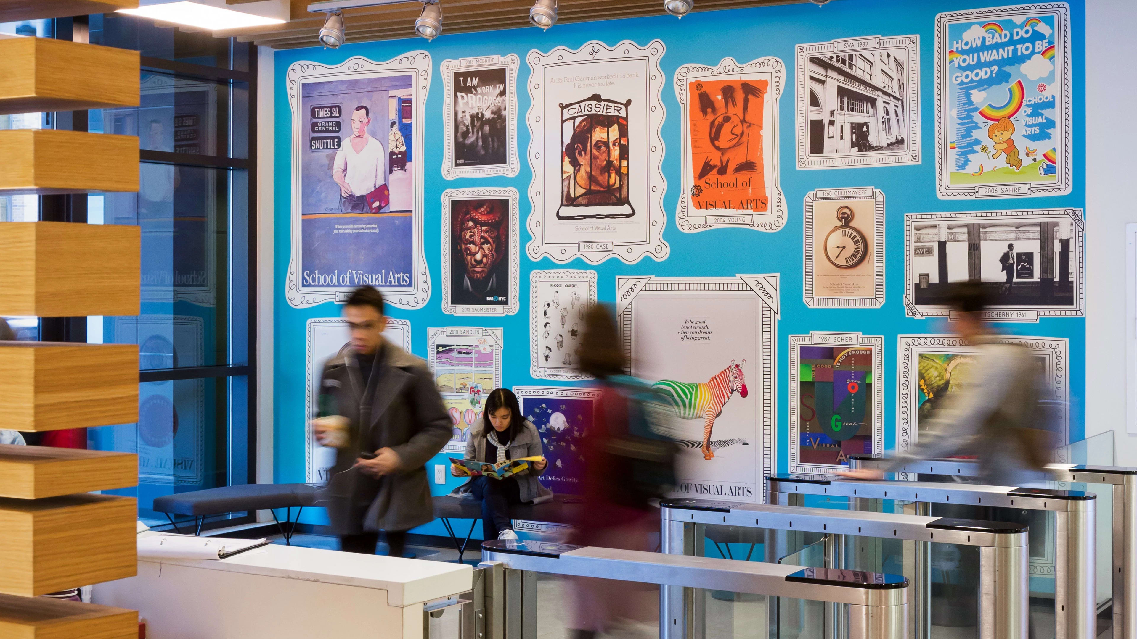 Interior of a residence hall adorned with archival SVA subway posters on a sky blue wall