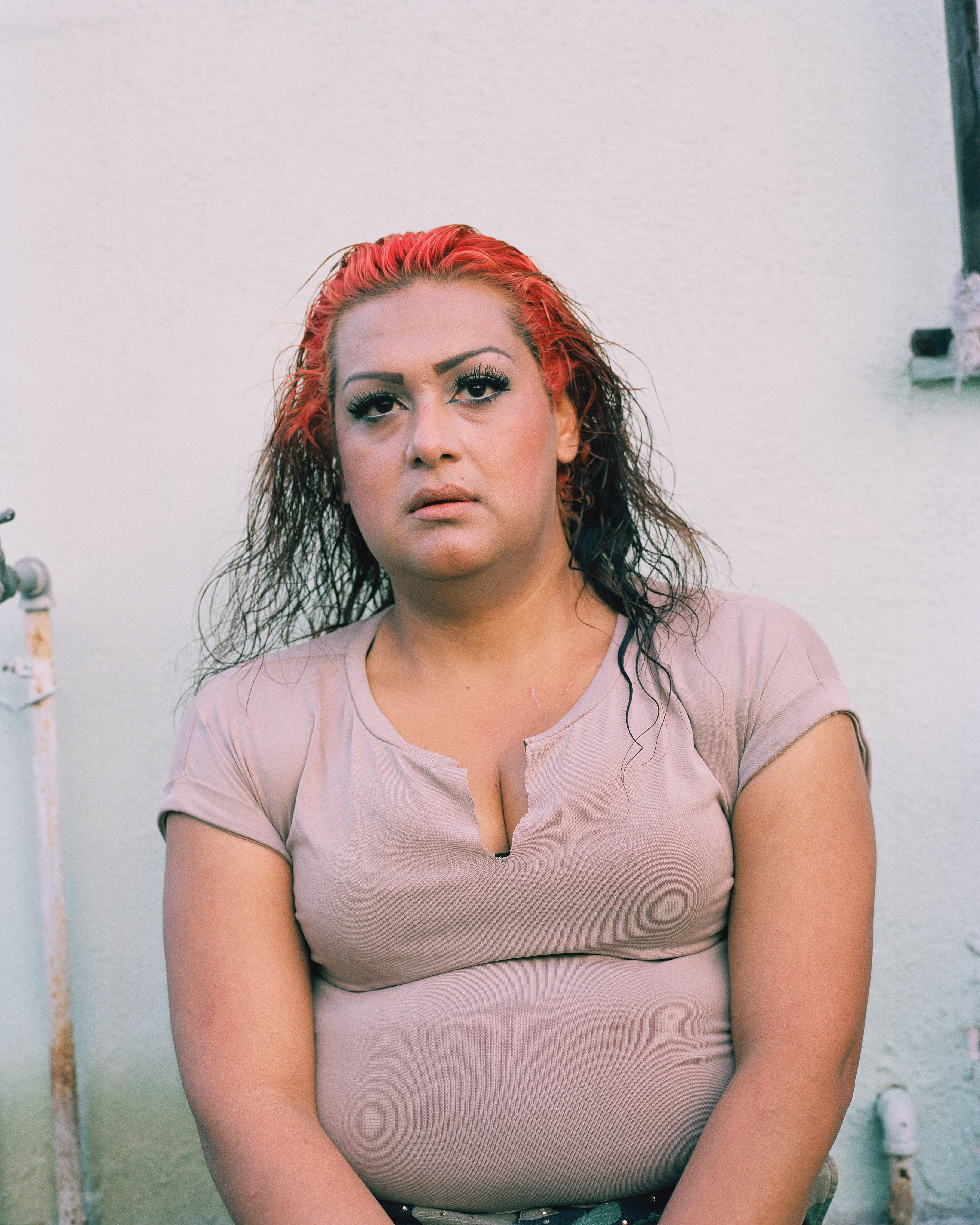 A photograph of a woman with dyed red hair.