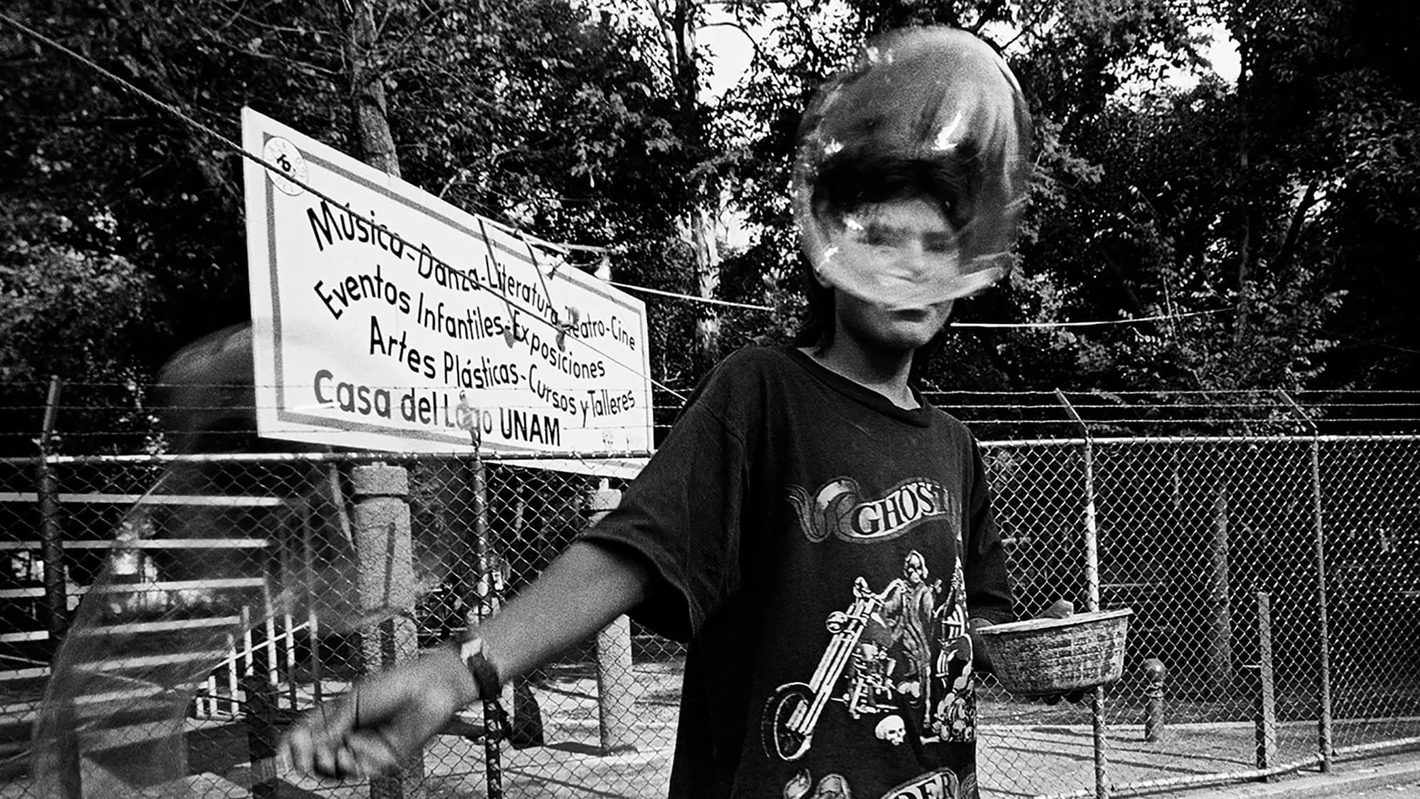 Youth making bubbles in a Mexico City park, bubble in front of his face