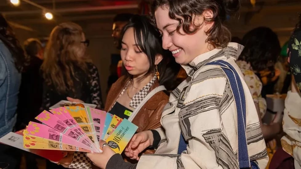 Two students looking at a sprawled out swatch book,