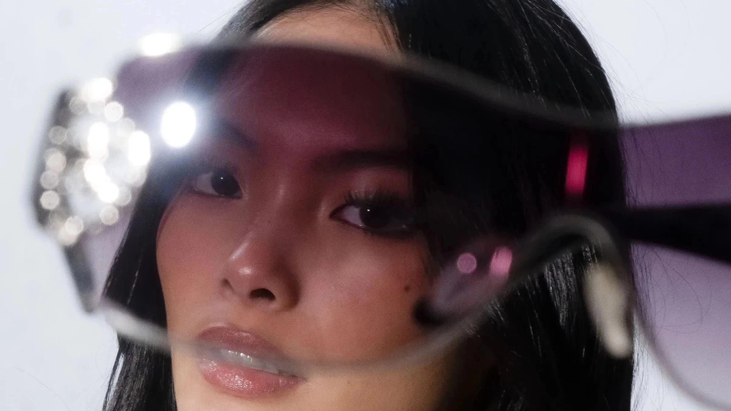 A woman's face peering through glasses