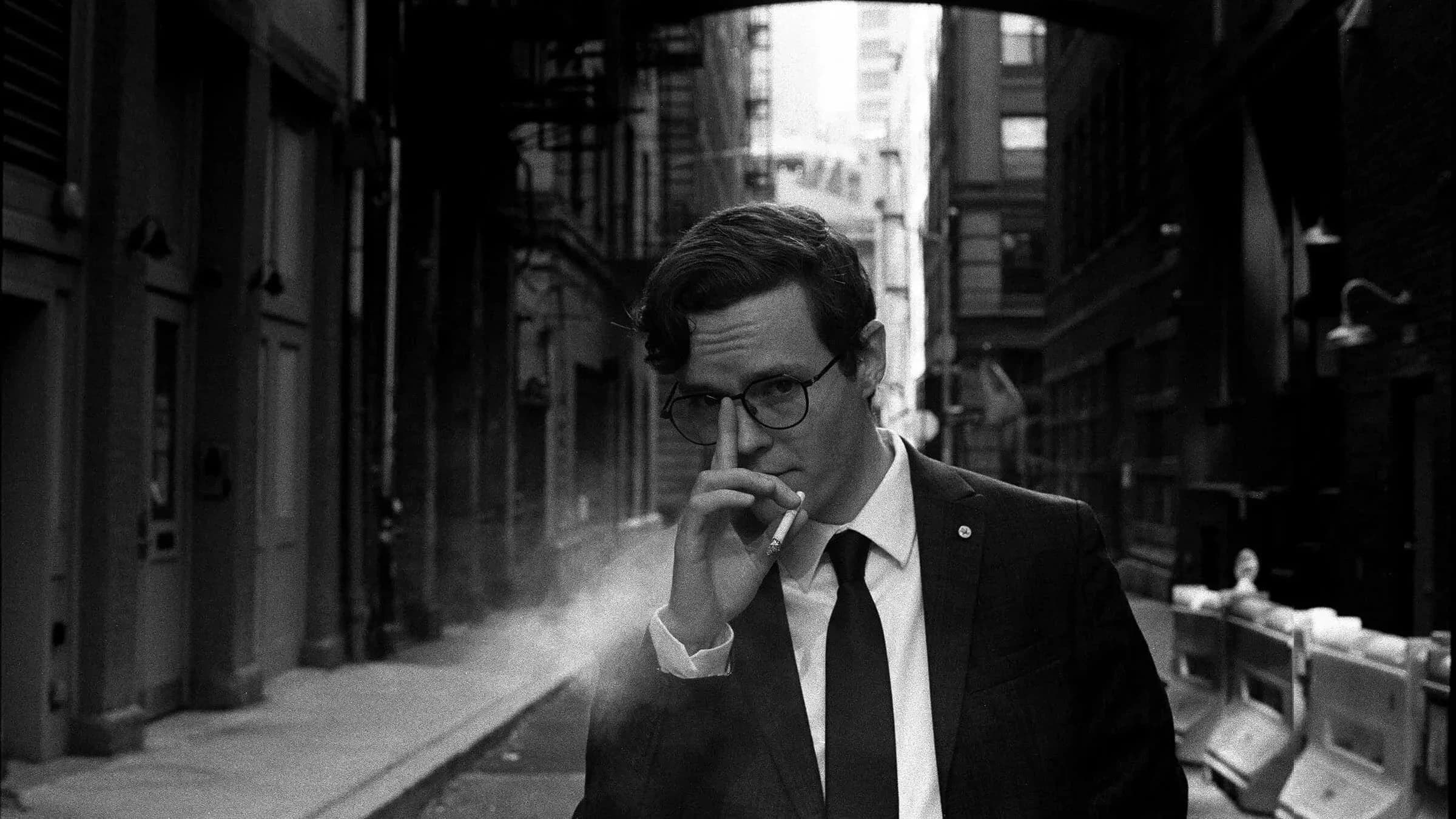 A man holding a cigarette in an alley