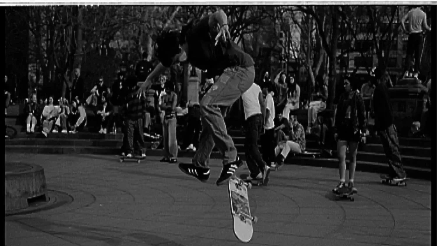 Male skateboarder doing a kickflip photographed mid-air.