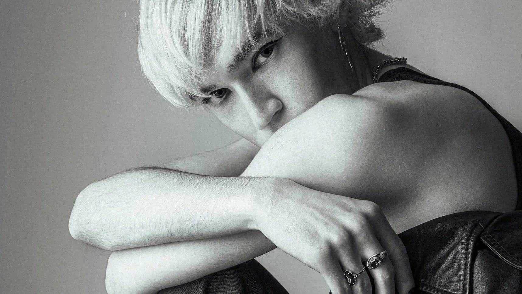 A black and white portrait of Stephen crouched down