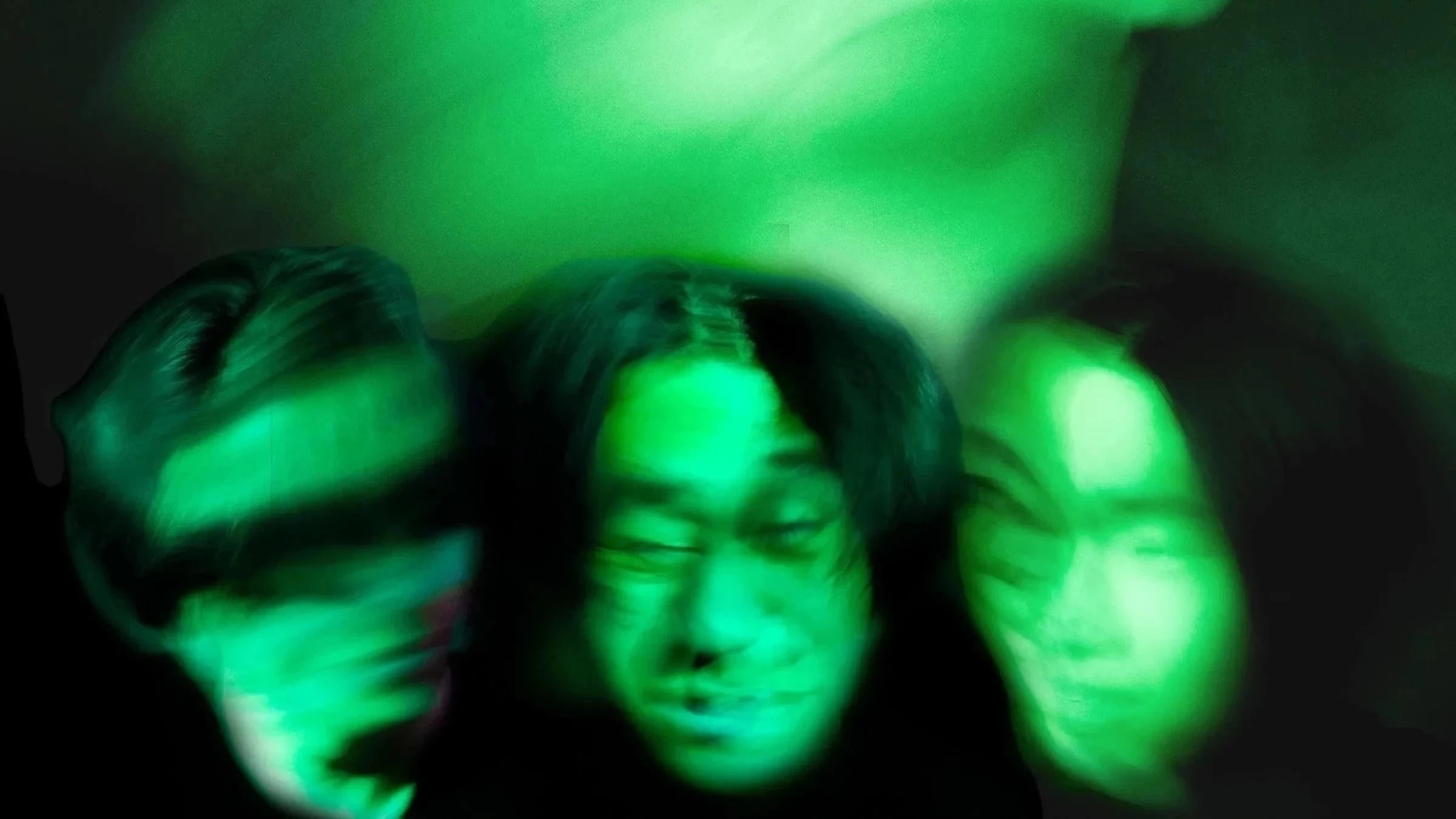 a black and green photo of blurred faces