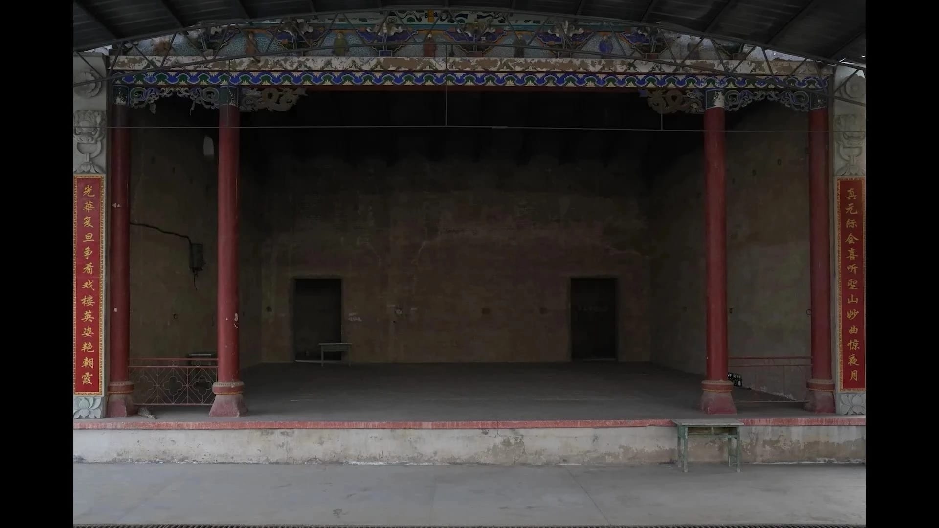 A grey and red buliding with pillars.