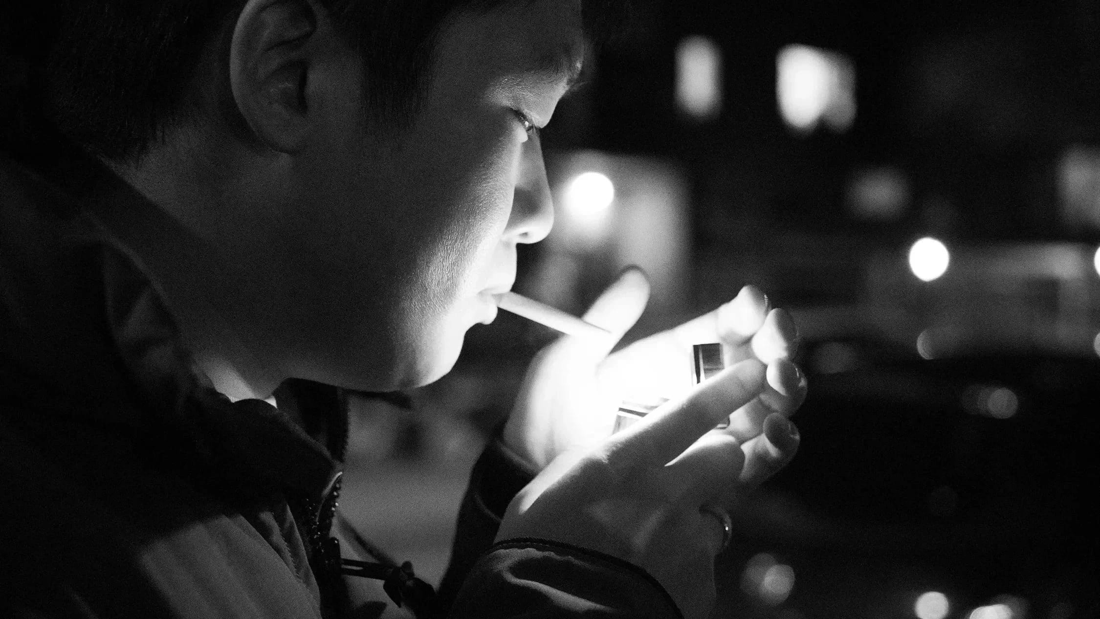 In the cold and windy winter, a man lights a cigarette