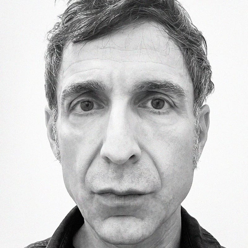 Black and white image of a man looking at the camera.