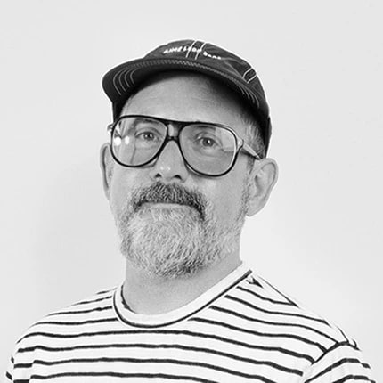 black and white portrait of a man with glasses and a hat