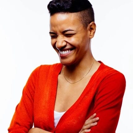 Glendalys Medina smiling in a red shirt with arms crossed 