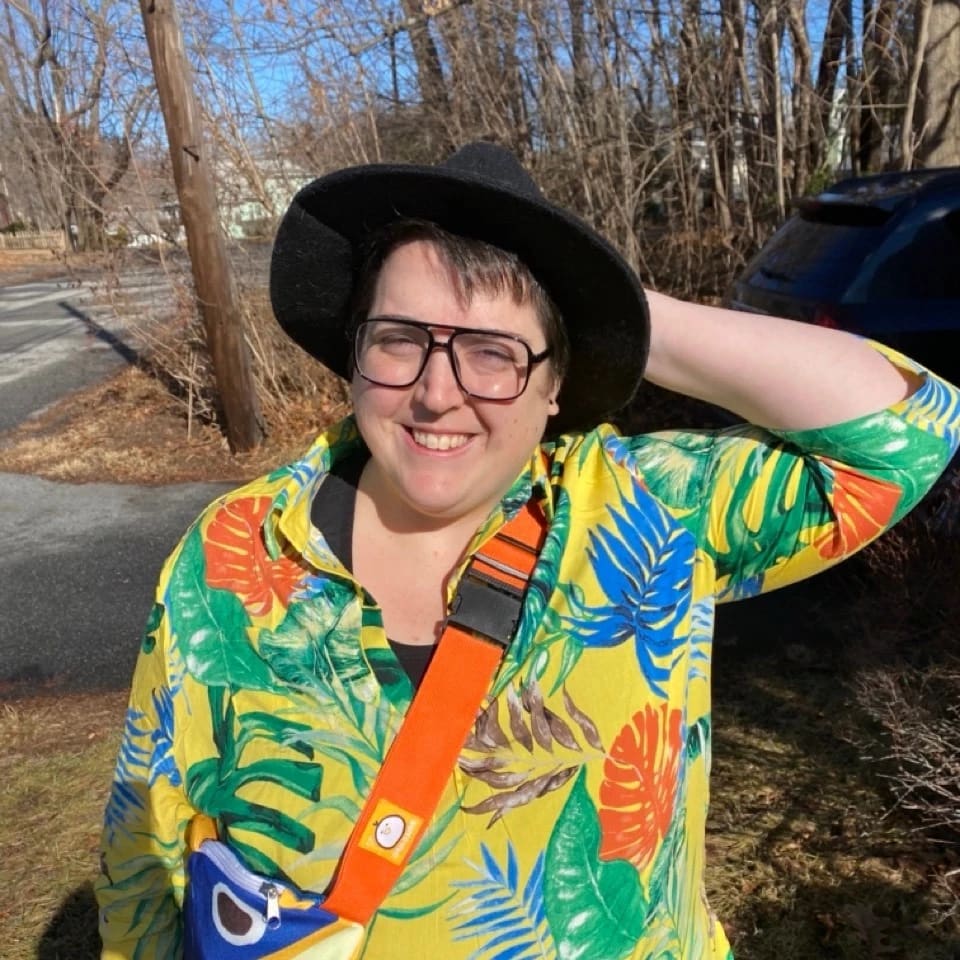 Whitney Leopard outside in a hat and tropical shirt. 