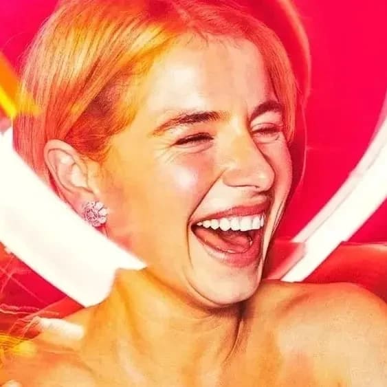 A person in a strapless dress joyfully holds a golden trophy. Behind her, a vibrant red and white heart-shaped light glows, adding a celebratory tone.