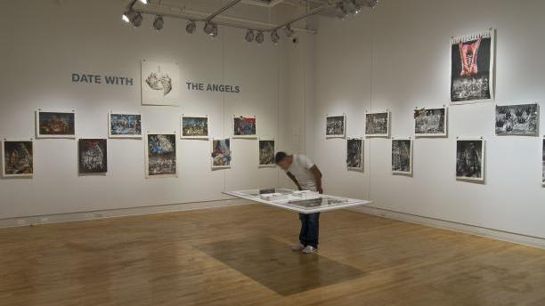 A man looks down at an installation in an art exhibit