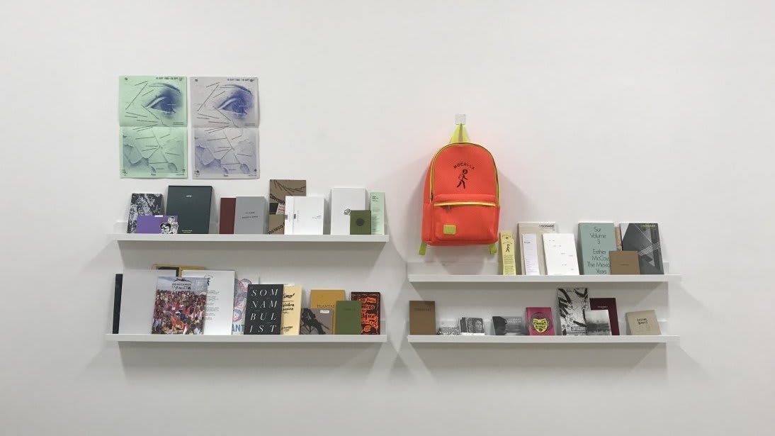 An image of a shelf stacked with books and a book bag.