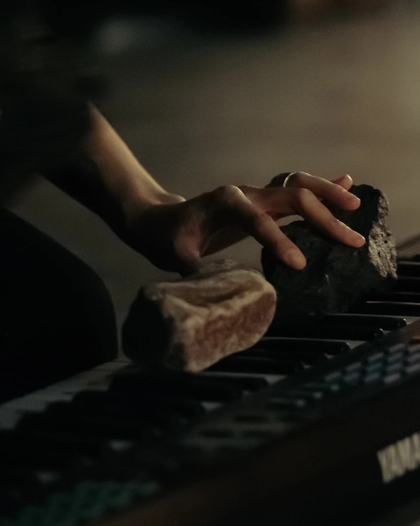 Photographic image of a hand one a keyboard. The keyboard has two ricks on it.