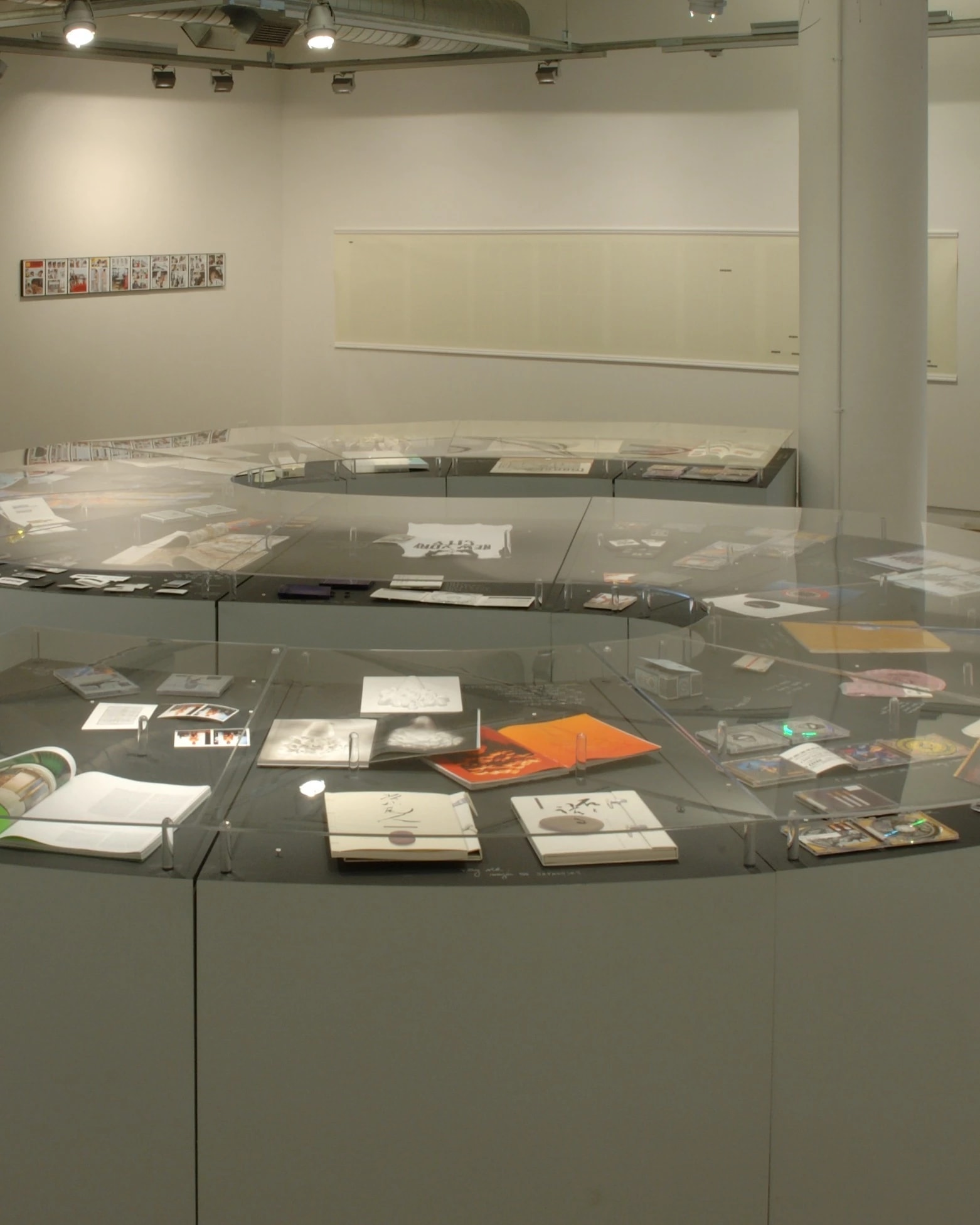 A curved counter, in the shape of an "S," displays books and prints within it. 