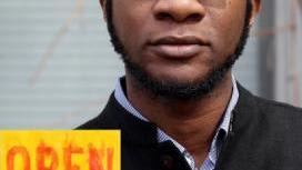 A young black male poses with a book cover