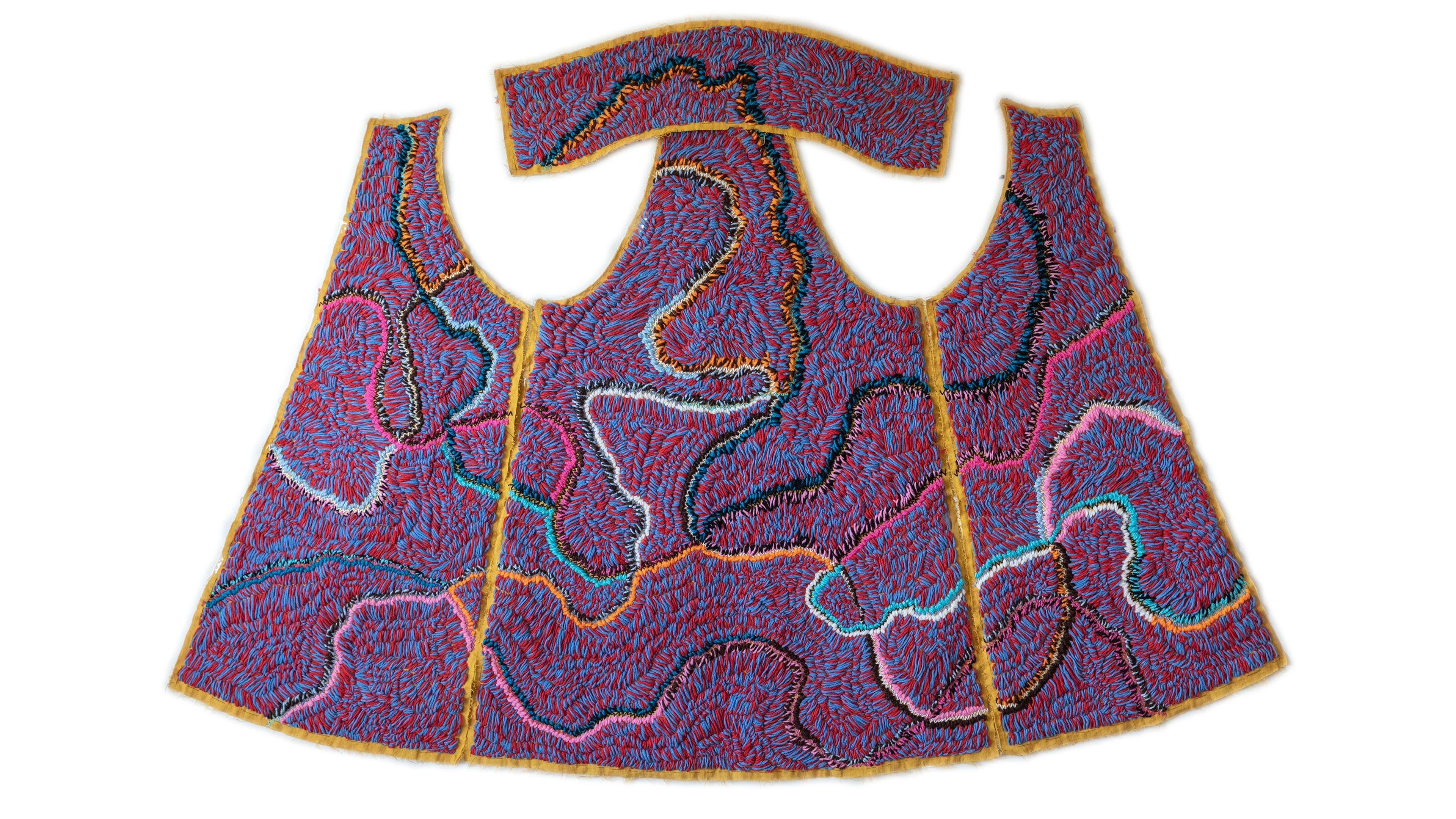 Purple sewn panels that look to be in the shape of a disassembled vest. The panels have colorful swirls embroidered on top of it and orange trim.