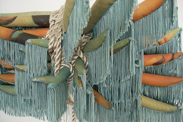 Close up picture of a multi-media piece of art made with cord, rope, and other matter.