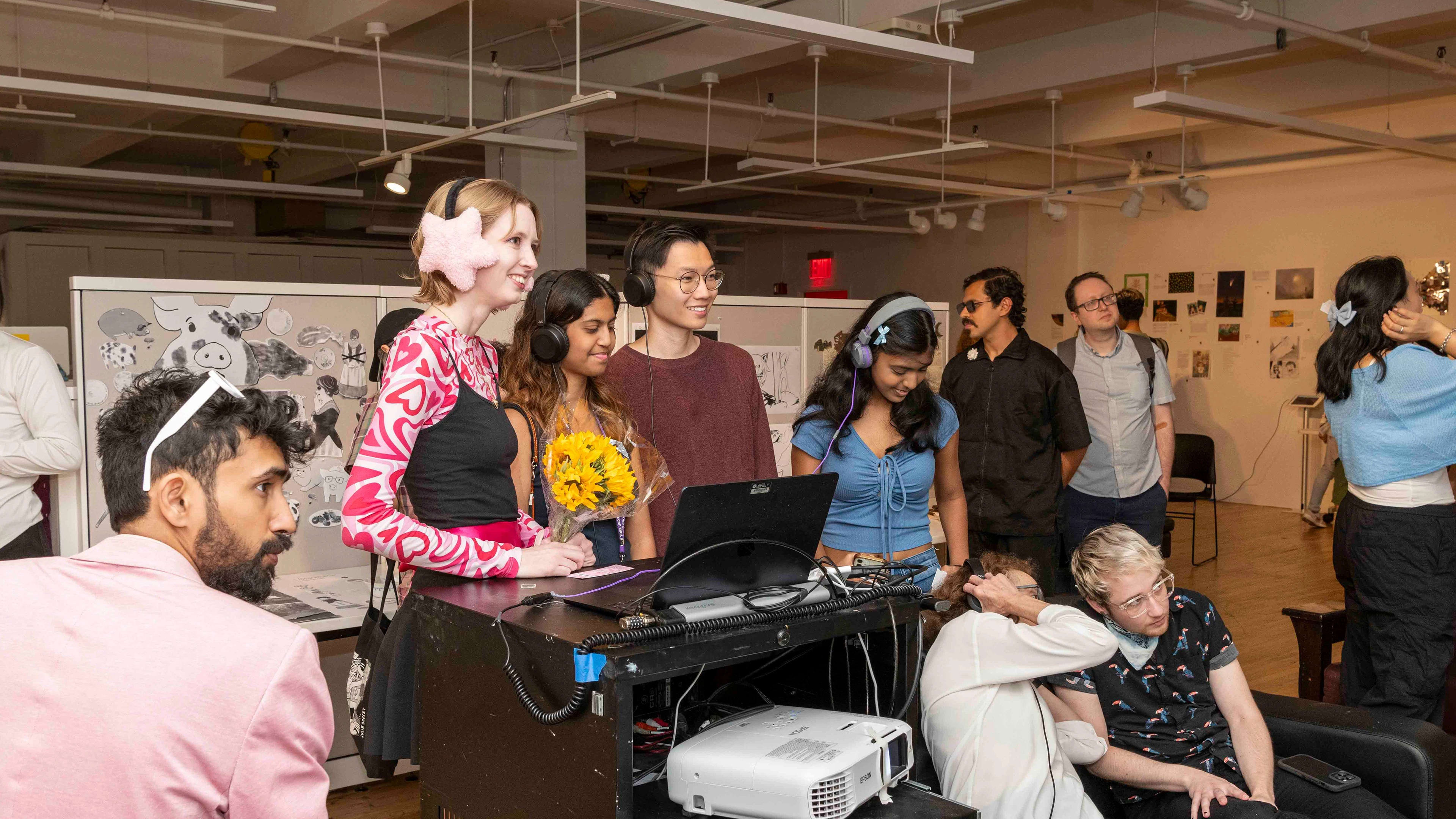 Group of students stand in front of a projector in a classroom.
