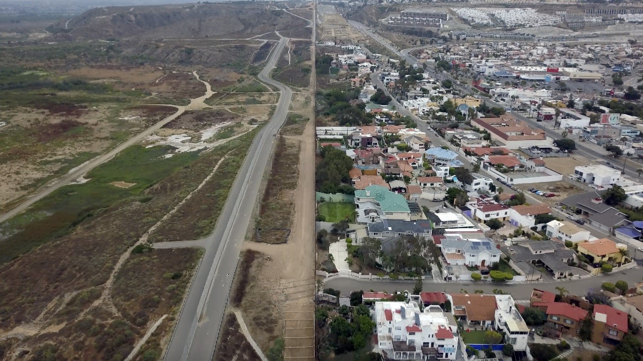 An image showing the contrast between two pieces of land, one filled with houses and another barren land