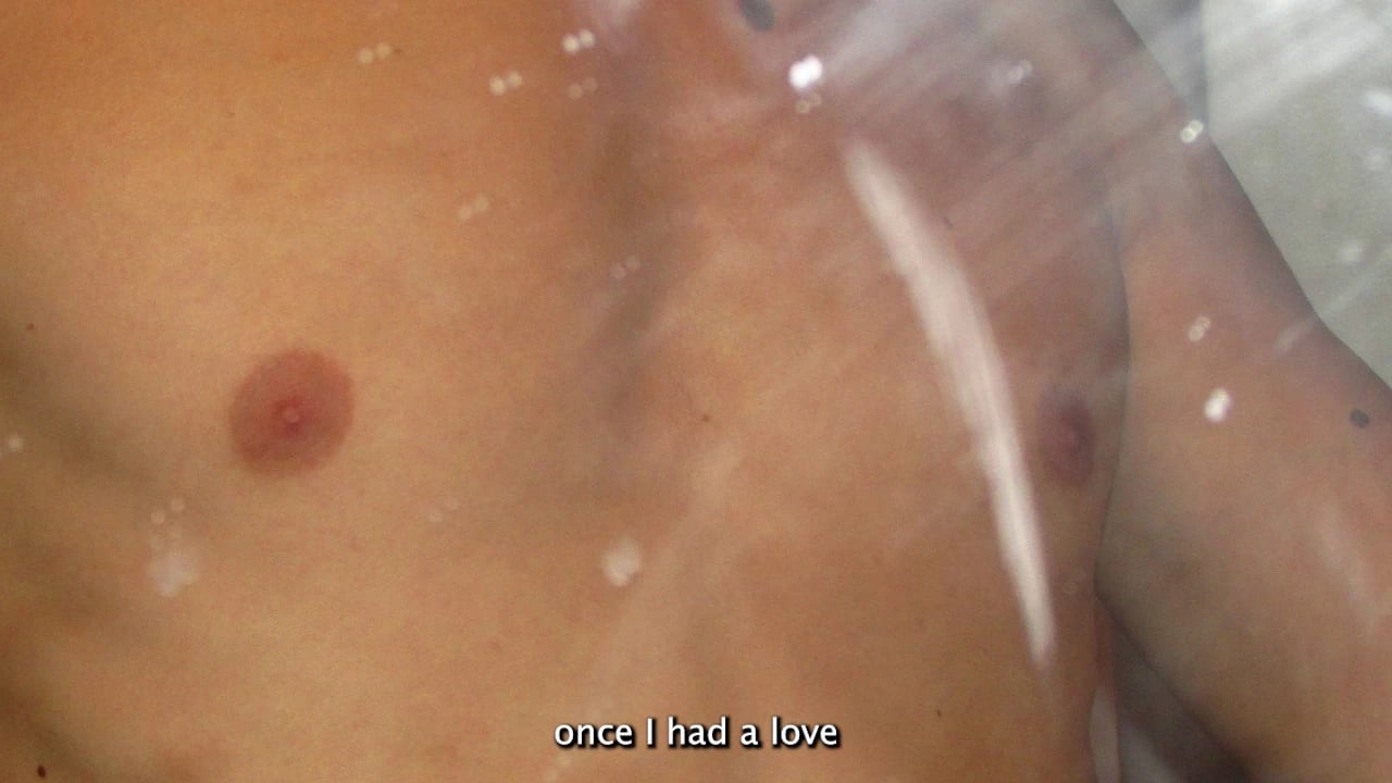 video still showing a closeup of a chest in a shower, with a subtitle reading once I had a love at the bottom of the frame