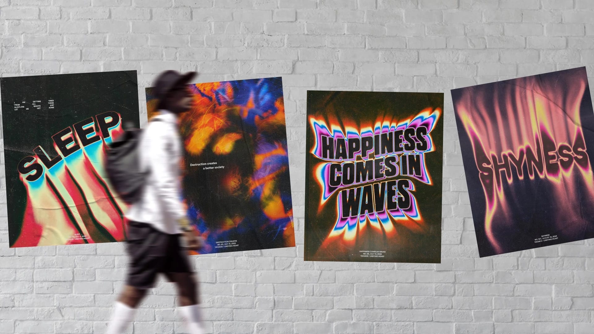 A man walks past a white brick wall on which four posters hang askew.