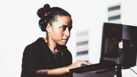 Woman operating Apple laptop and sound desk