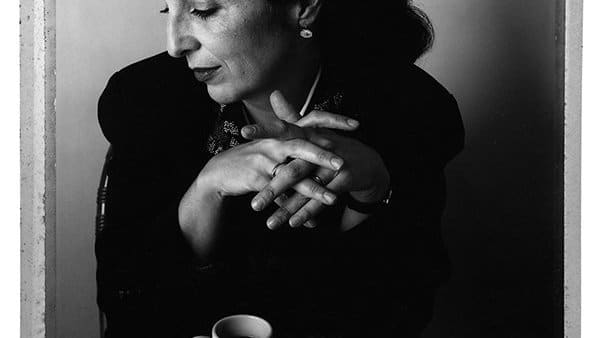 Woman posing for a picture with a coffee mug and two pencils